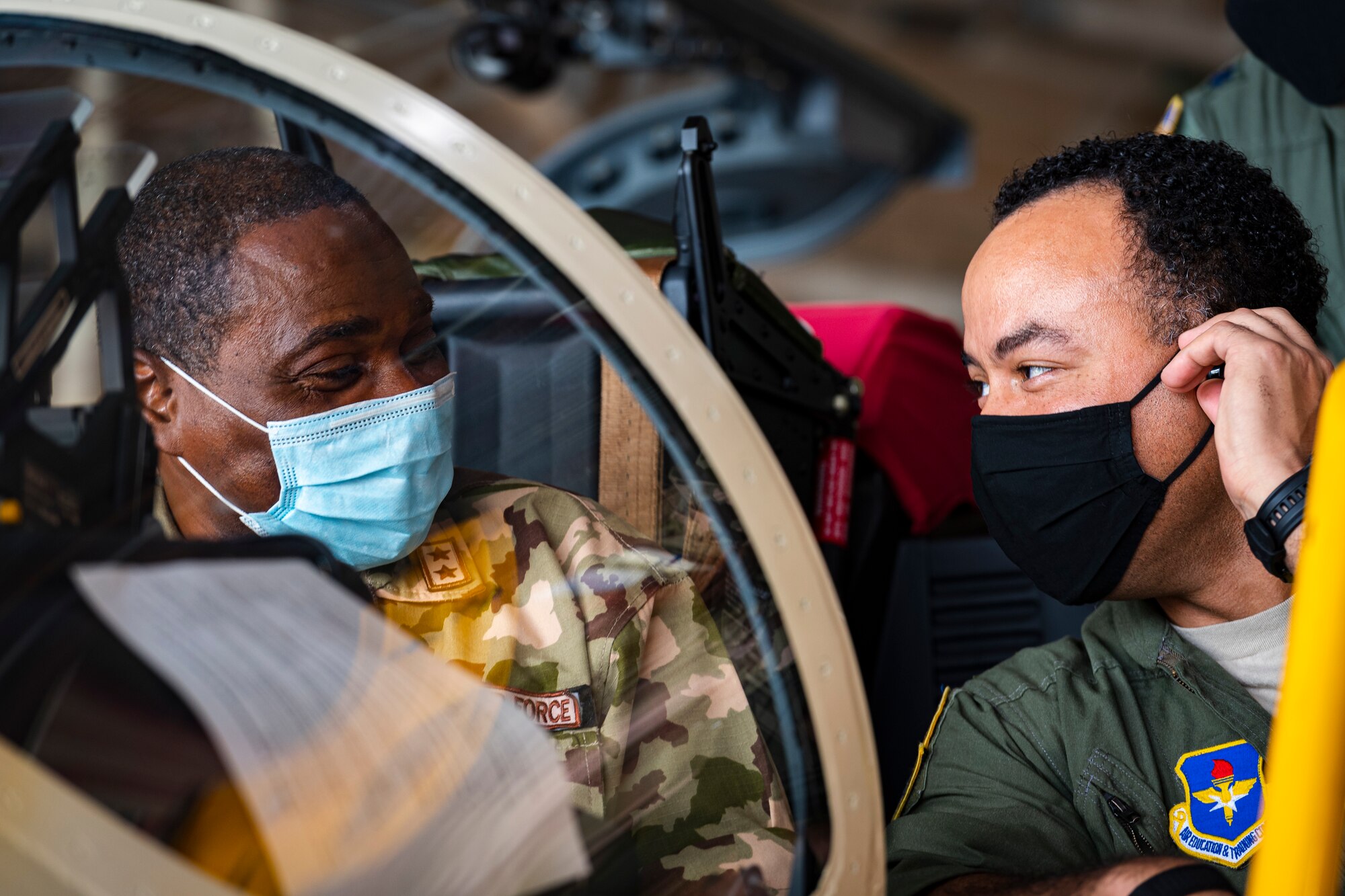A photo of an Airman showing another Airman an aircraft