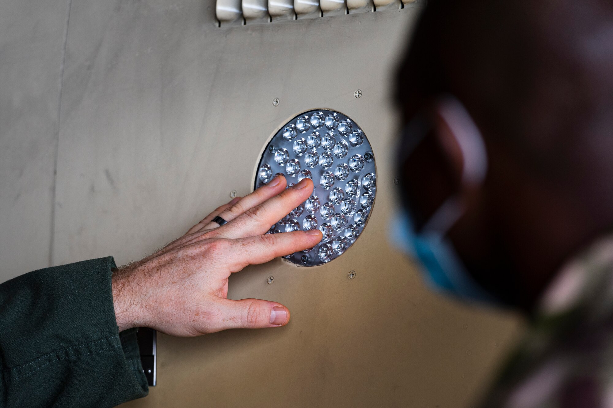 A photo of an Airman pointing to an aircraft light