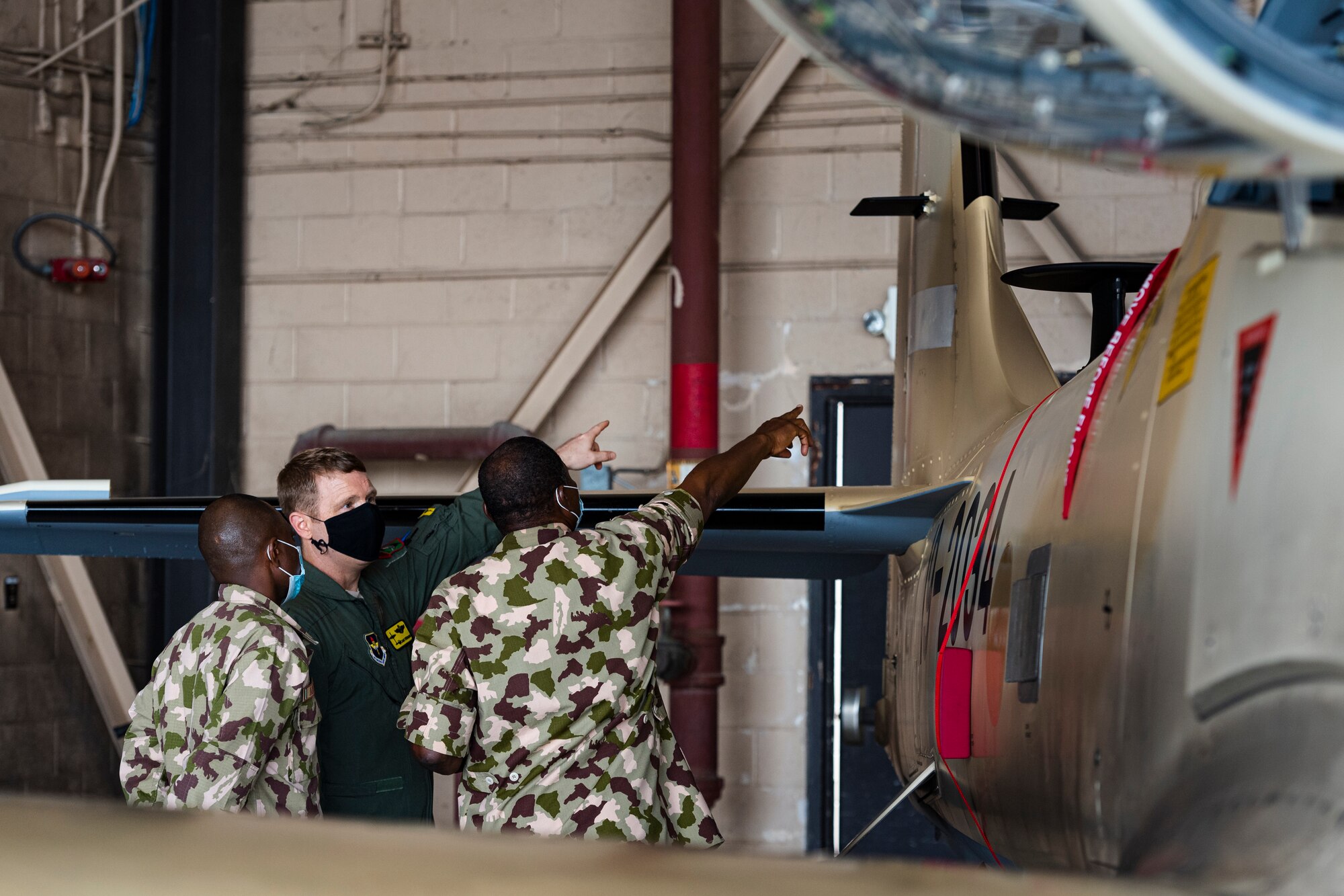 A photo of Airmen pointing at an aircraft
