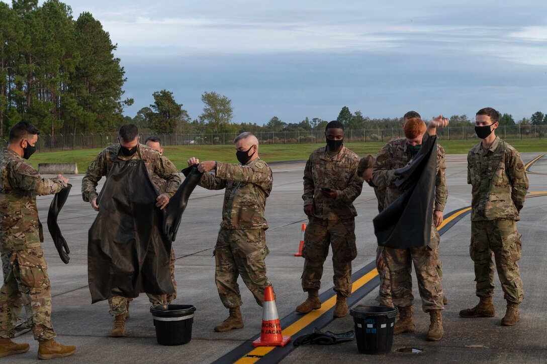 A photo of Airmen donning personal protective equipment