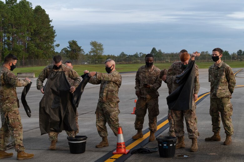 A photo of Airmen donning personal protective equipment