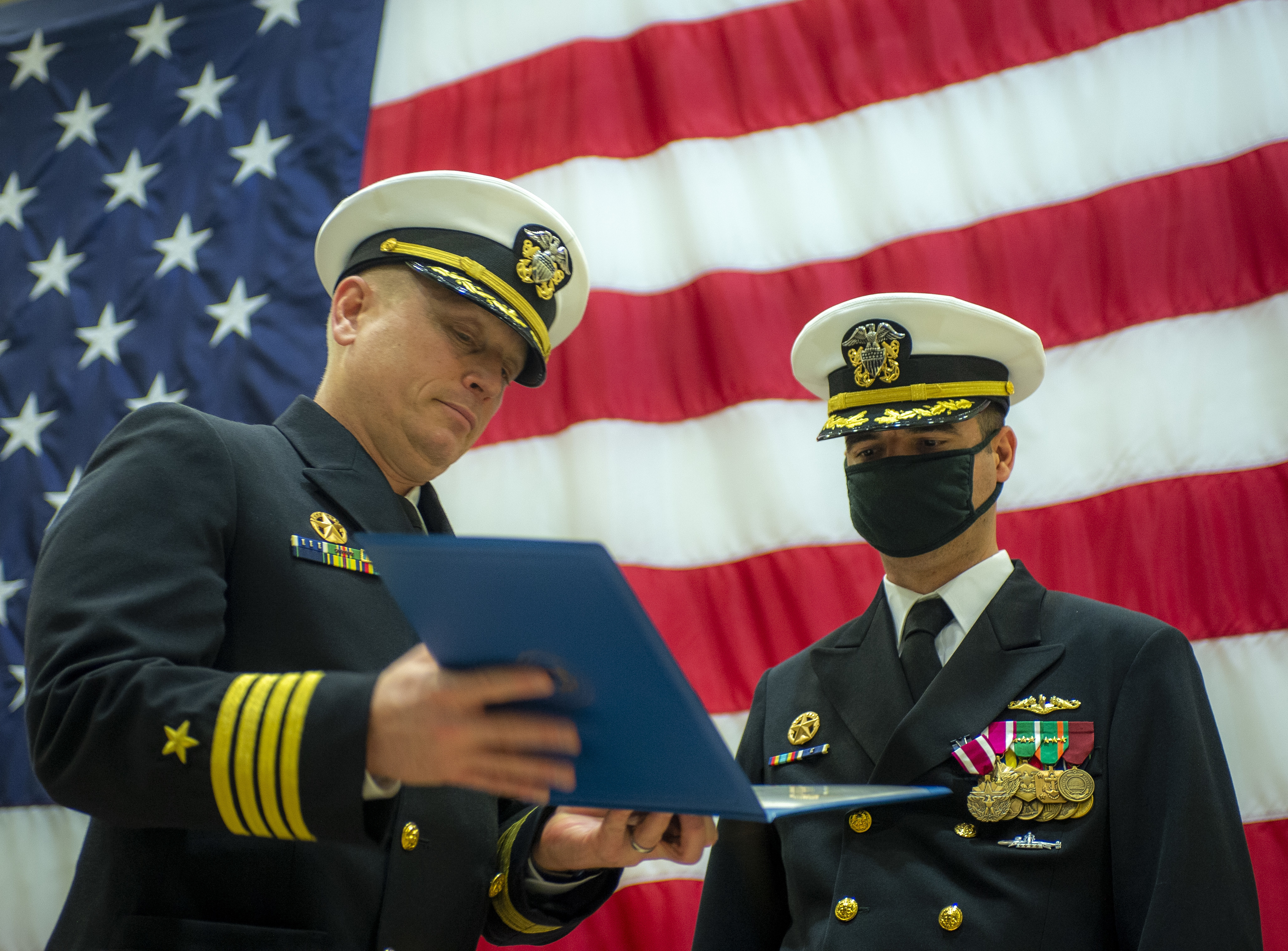 Capt. Jeffrey Juergens, commodore, Submarine Squadron 6, presents Cmdr. Kristopher Lancaster with an award during a change of command ceremony for the Los Angeles-class attack submarine USS Boise (SSN 764) at Naval Station Norfolk, Oct. 30, 2020.