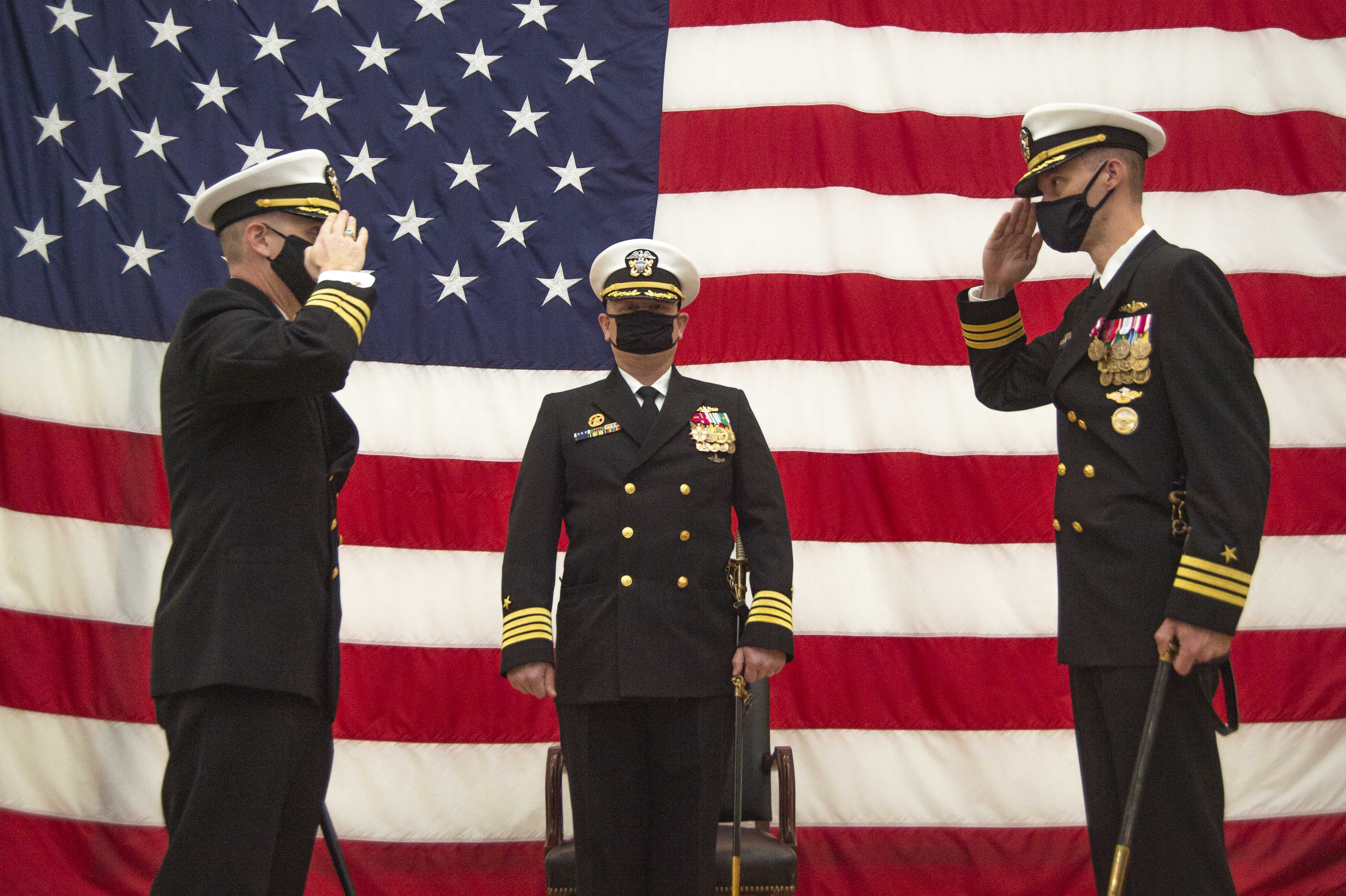 Cmdr. Richard McCandless, left, assumes command from Cmdr. Mathias Vorachek, right, while Capt. Jeffrey Juergens, commodore, Submarine Squadron Six, center, presides during the Los Angeles-class attack submarine USS Albany (753) change of command ceremony onboard Naval Station Norfolk, Oct. 30, 2020.