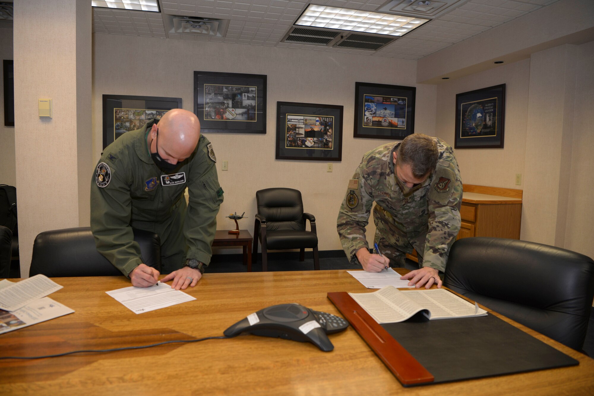 U.S. Air Force Col. David Berkland, the 354th Fighter Wing (FW) commander, and Chief Master Sgt. John Lokken, the 354th FW command chief, sign Combined Federal Campaign (CFC) donation slips on Eielson Air Force Base, Alaska, Oct. 28, 2020.