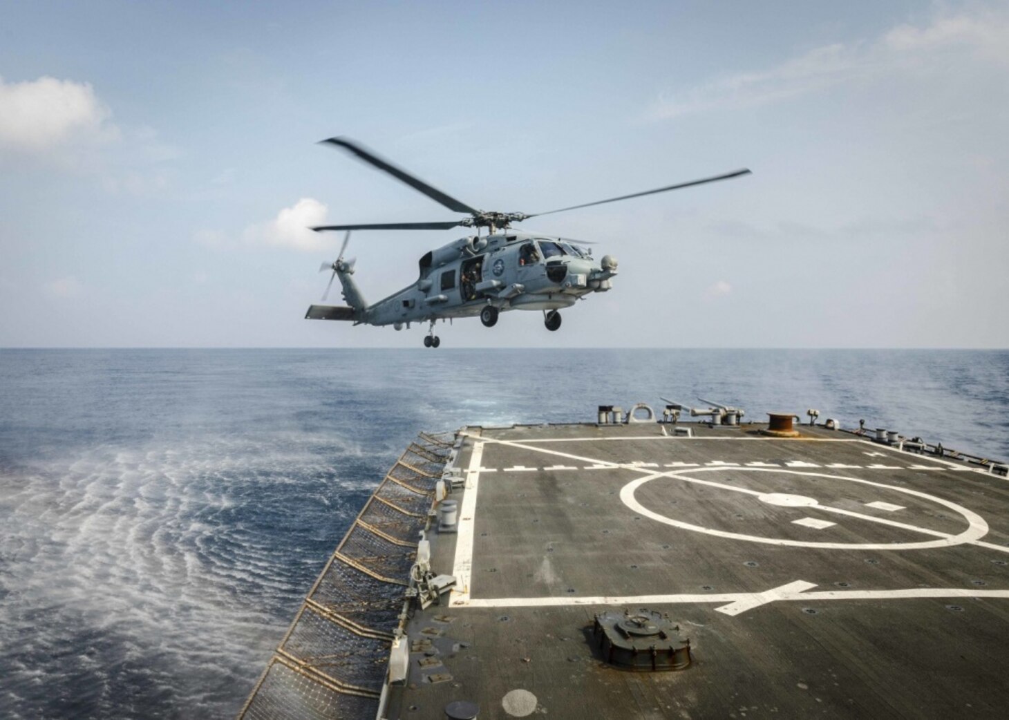 An MH-60R Sea Hawk helicopter from the Royal Australian Navy Anzac-class frigate HMAS Ballarat (FFH 155) prepares to land on the flight deck aboard the Arleigh Burke-class guided-missile destroyer USS John S. McCain (DDG 56) during flight operations. McCain is assigned to Destroyer Squadron Fifteen (DESRON 15), the Navy’s largest forward-deployed DESRON and the U.S. 7th Fleet’s principal surface force.