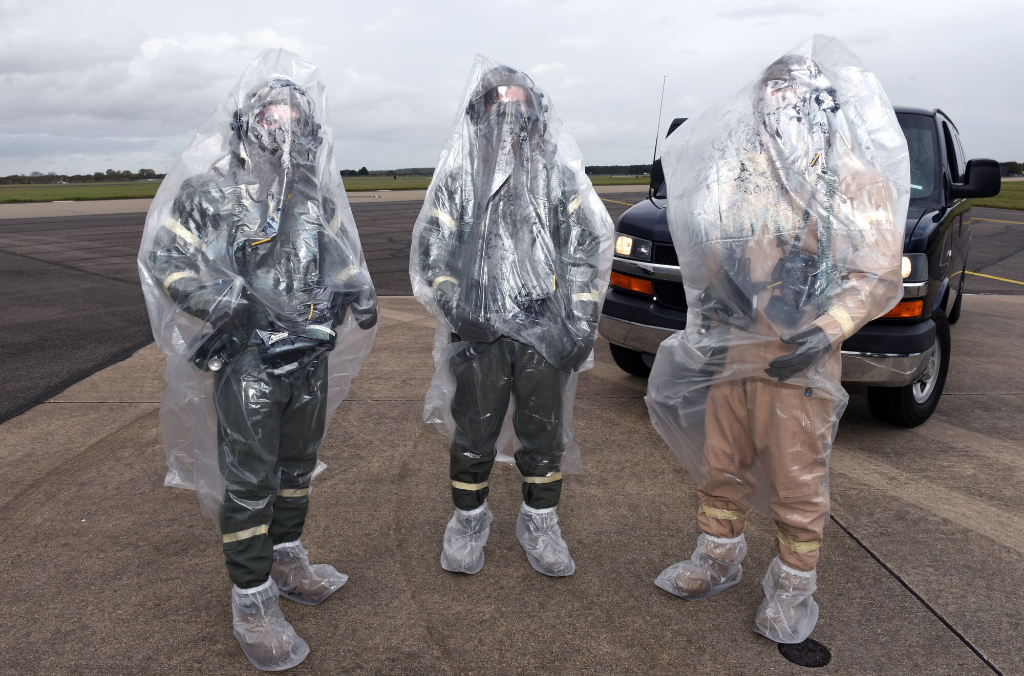 U.S. Air Force aircrew from the 351st Air Refueling Squadron wear aircrew eye and respiratory protection equipment when arriving at their aircraft during a chemical, biological, radiological and nuclear exercise at Royal Air Force Mildenhall, England, Oct. 28, 2020. The scenario simulated an aircraft in a hangar when the aircrew arrived and carried out decontamination procedures. The bags were removed by crew chiefs before the pilots and boom operator climbed the ladder into the cockpit, to ensure no contaminants were brought into the aircraft. (U.S. Air Force photo by Karen Abeyasekere)
