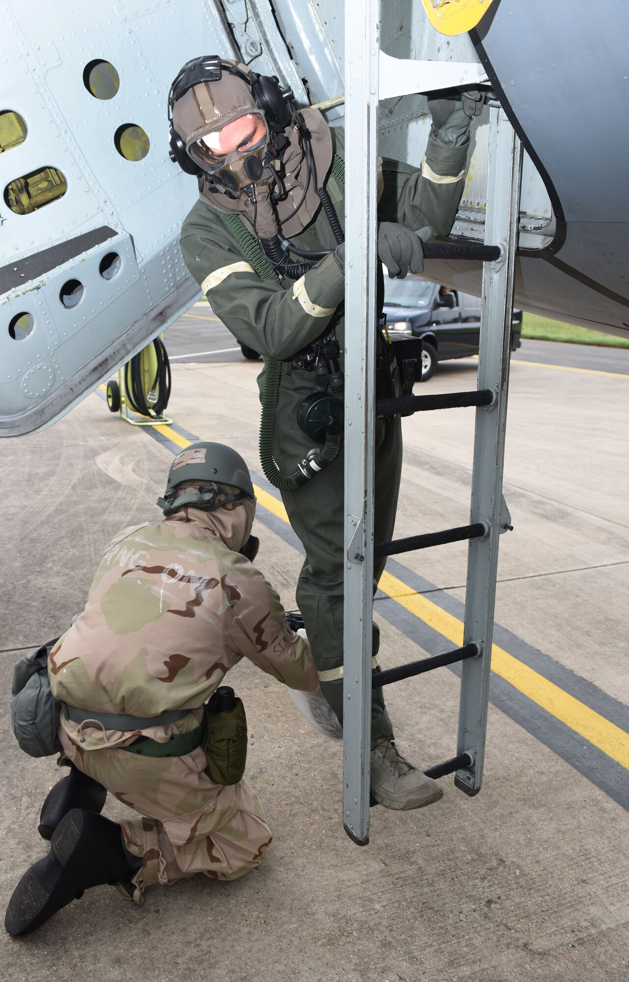 U.S. Air Force Airman 1st Class Cooper Murphy, 100th Aircraft Maintenance Squadron crew chief, removes overboots from an aircrew member’s boots as part of decontamination procedures aircraft during a chemical, biological, radiological and nuclear exercise at Royal Air Force Mildenhall, England, Oct. 28, 2020. The scenario simulated the aircraft being in a hangar when the aircrew arrived and carried out decontamination procedures to ensure no contaminants were brought into the aircraft. (U.S. Air Force photo by Karen Abeyasekere)