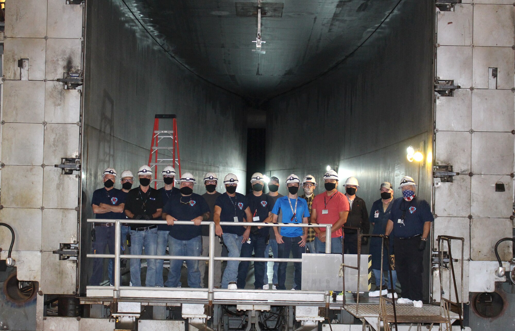 The team working to reactive the Arnold Engineering Development Complex 16-foot supersonic wind tunnel nozzle at Arnold Air Force Base stands in the nozzle of the test cell Sept. 25, 2020. The nozzle which has not been operational since a test in 1997 is now active. (U.S. Air Force photo by Deidre Moon) (This photo has been altered by obscuring badges for security purposes.)