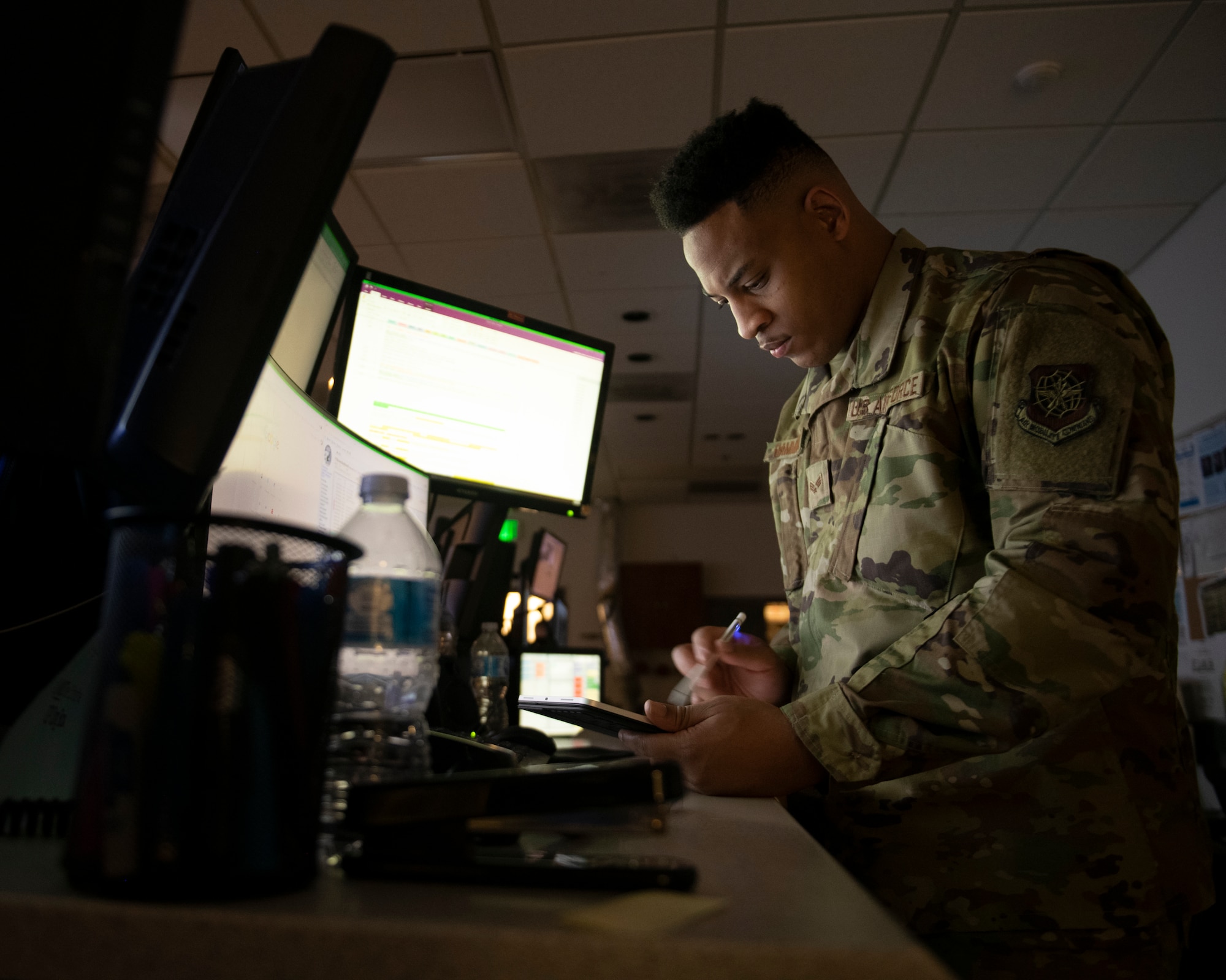 U.S. Air Force Senior Airman Isaiah Hammond, 60th Air Mobility Wing Command Post emergency actions controller, references his notes on an electronic tablet Oct. 16, 2020, at Travis Air Force Base, California.