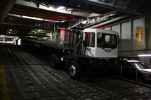 A member from the 841st Transportation Battalion is directed to move a vehicle down a vessel’s ramp at Joint Base Charleston’s Naval Weapons Station, S.C., Oct. 29, 2020. The battalion’s efforts helped support the transport of assets to Southwest Asia. The 841st TB facilitates the onward movement for all eastern seaboard cargo movements.