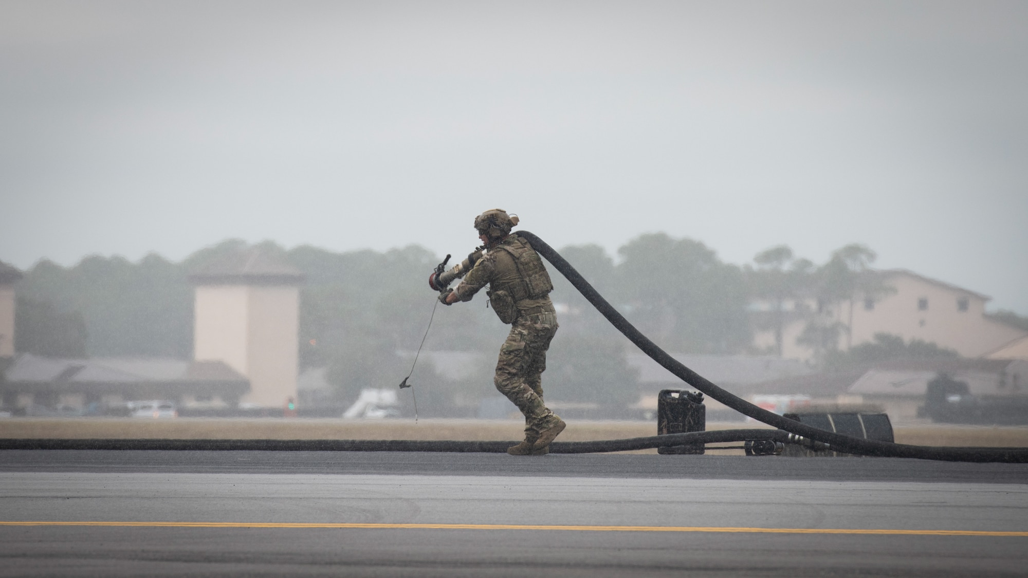 Airmen pulling fueling hose
