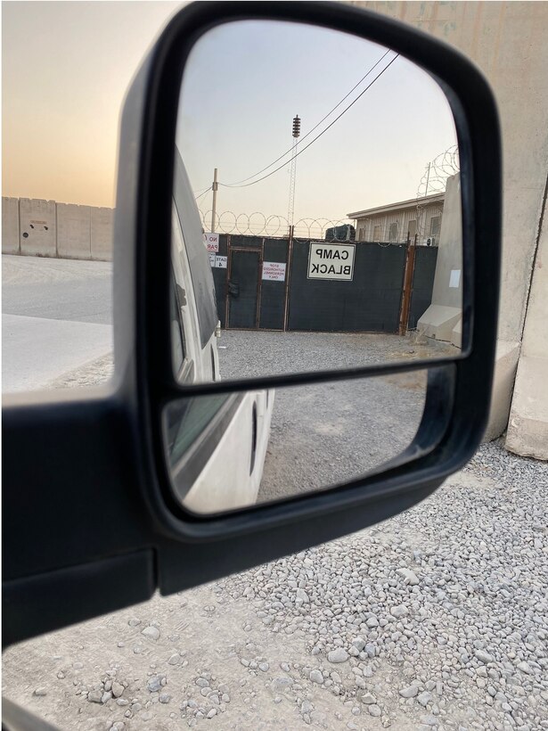 In this symbolic rear view mirror image, the Camp Black sign is shown upon departure to the passenger terminal, signaling OSI Expeditionary Detachment 2413 Task Force Black reaching its End of Mission. (Courtesy photo)