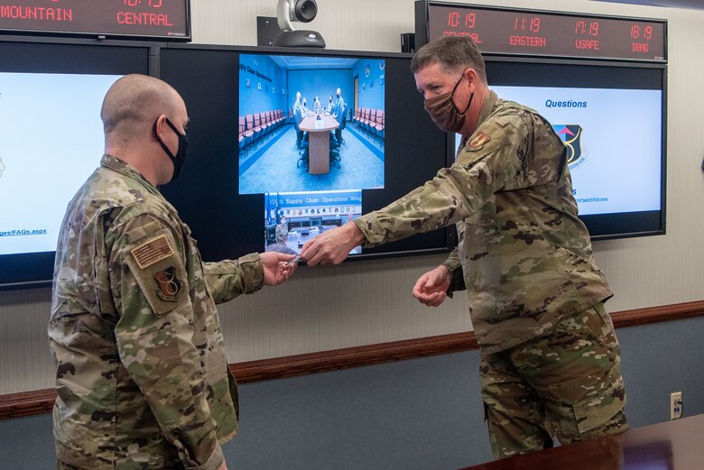 Technical Sgt. David Harper, manager, Fighters Repair Network Management of the 635th Supply Chain Operations Wing receives a coin from Air Force Lt. Gen. Gene Kirkland, Air Force Sustainment Center commander on Oct. 19.