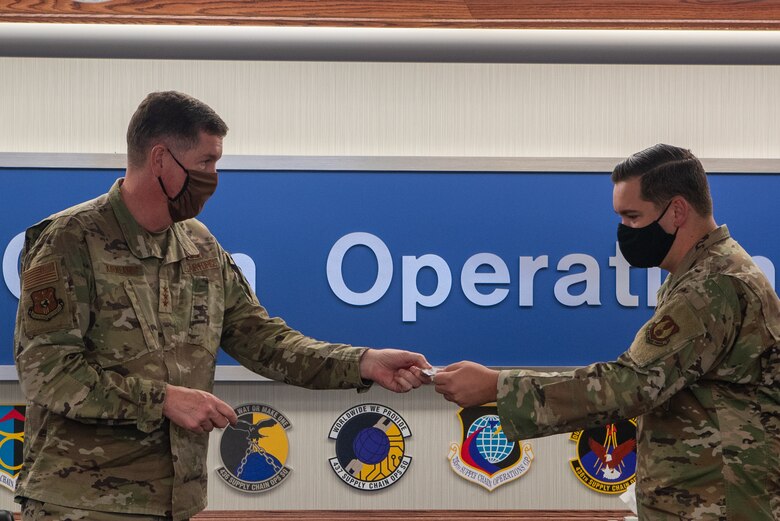 Technical Sgt. David J. Kalinowski, NCOIC, General Support Division of the 435th Supply Chain Operations Squadron receives a coin from Air Force Lt. Gen. Gene Kirkland, Air Force Sustainment Center commander on Oct. 19.