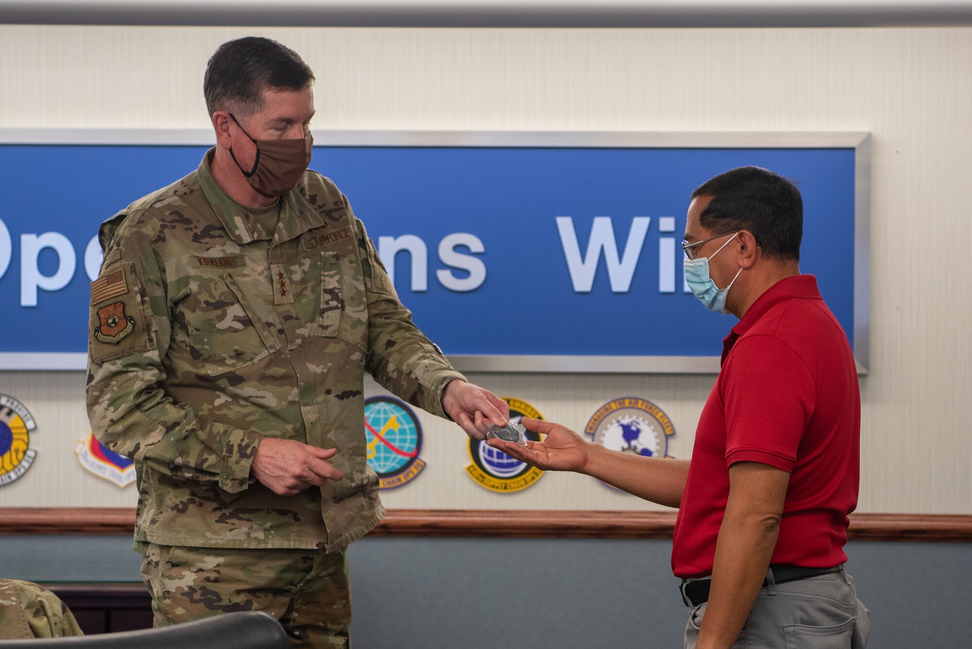 Gary Borges, Technical Support senior technician with the 437th Supply Chain Operations Squadron receives a coin from Air Force Lt. Gen. Gene Kirkland, Air Force Sustainment Center commander on Oct. 19.