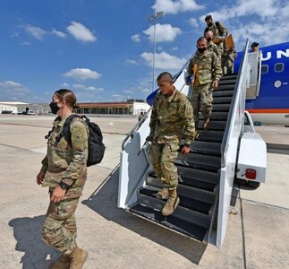 Soldiers depart from a chartered flight after arriving at Joint Base San Antonio-Kelly Field Annex from Fort Jackson, Mississippi.