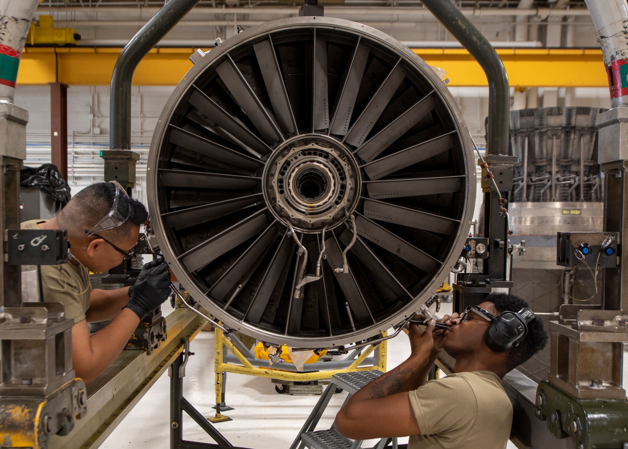 Senior Airman Joey Nakamura (left) and Senior Airman Shemar Nelson, 4th Component Maintenance Squadron aerospace propulsion technicians, work on an F-15E Strike Eagle engine at Seymour Johnson Air Force Base, North Carolina, Oct. 28, 2020.