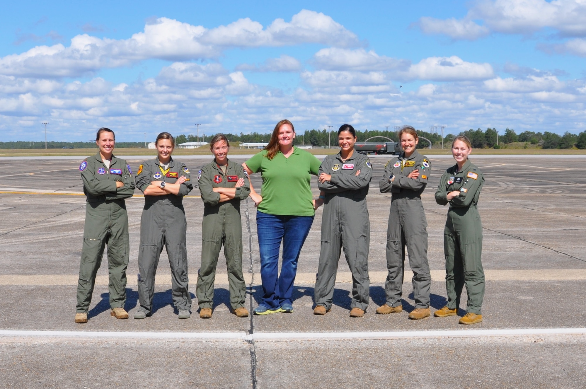 seven women stand on the flight line