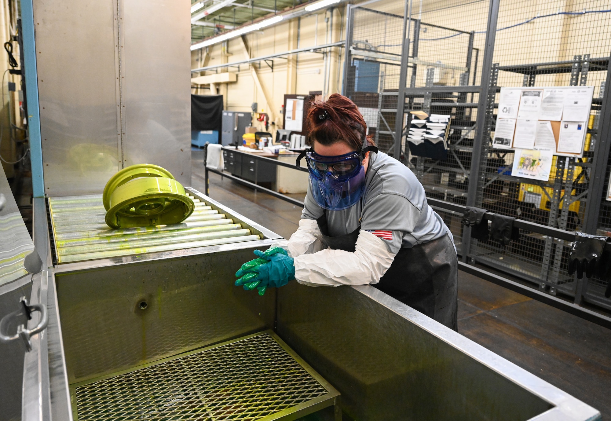 Peggy Archer, M1 Support Services nondestructive inspection lead waits for a piece of an aircraft to dry after it was dipped in a fluorescent penetrant on Oct. 29, 2020, at Columbus Air Force Base, Miss. The fluorescent penetrant is used to detect cracks in aircraft parts. (U.S. Air Force photo by Airman 1st Class Davis Donaldson)