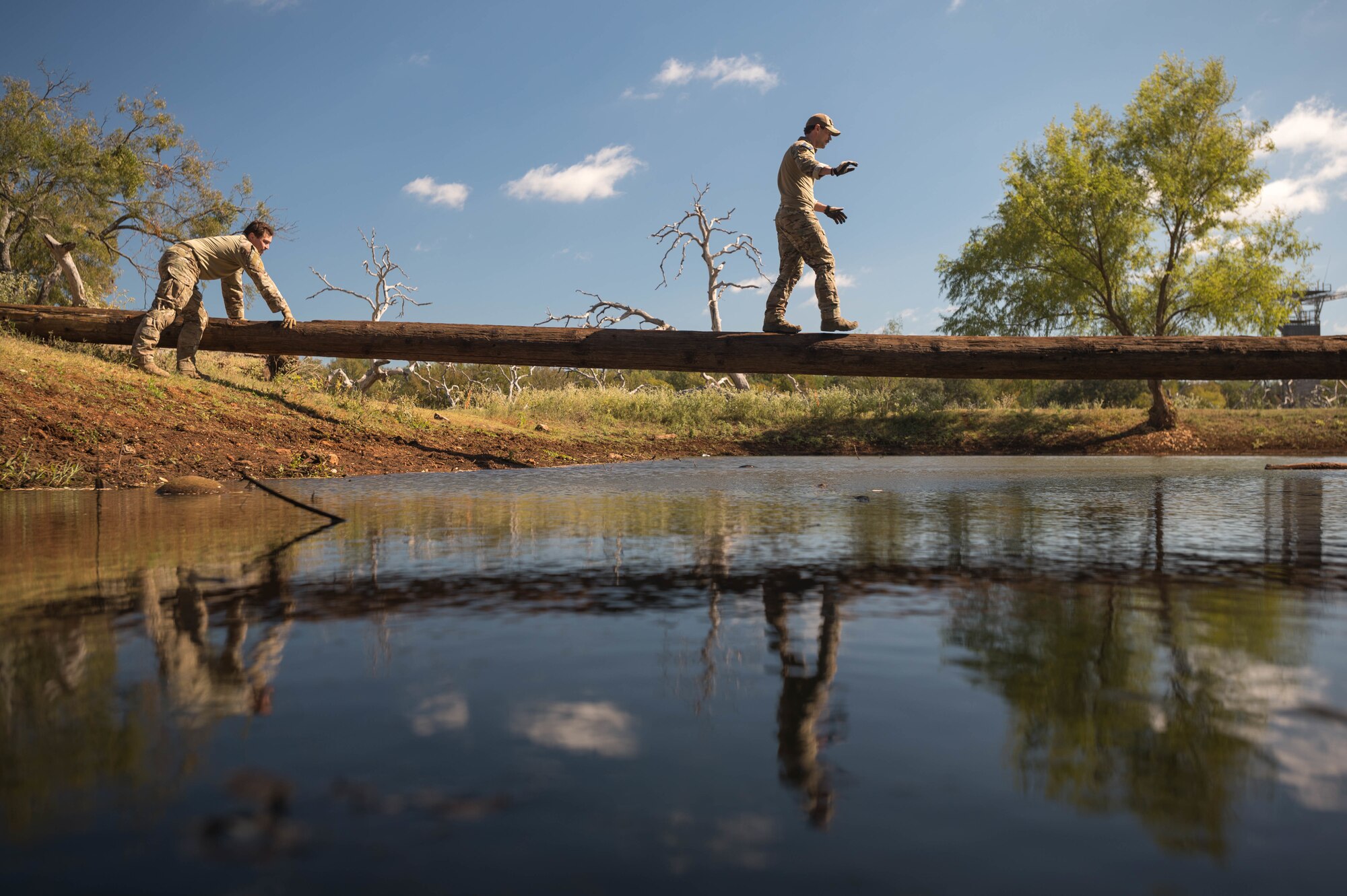 Airmen walk across beam