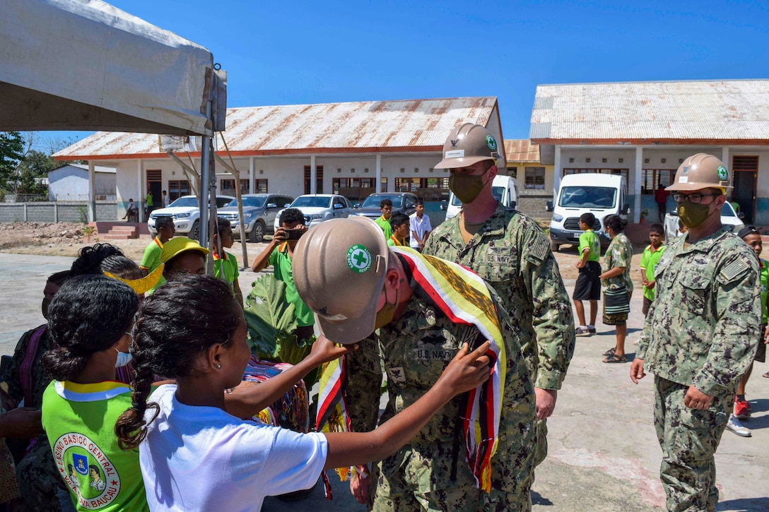 A group of young students give sailors clothes.