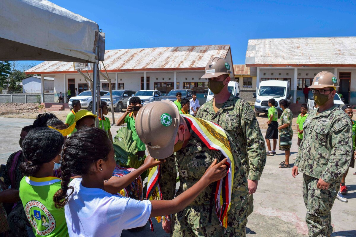 A group of young students give sailors clothes.