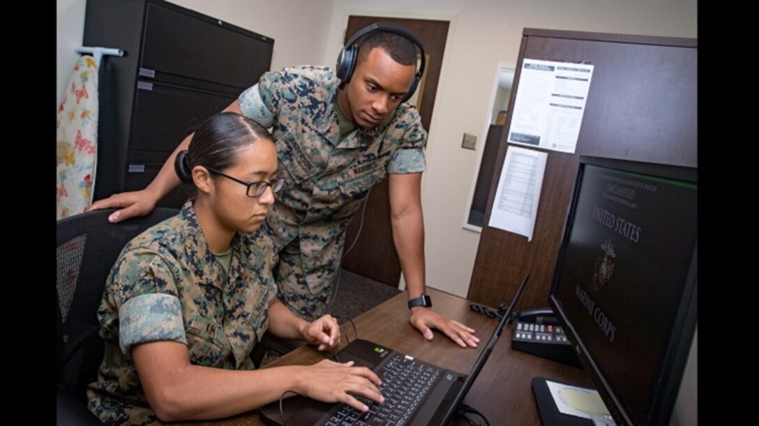 U.S. Marine Corps Sgt. Paul Anderson, right, court reporter non-commissioned officer in charge, and Lance Cpl. Christina Kim, a court reporter, both assigned to Headquarters and Headquarters Squadron, review audio files from a court case at the Legal Services building, Marine Corps Air Station Cherry Point, North Carolina, Aug. 8, 2019. Anderson and Kim are currently the only court reporters assigned to the Legal Service Support Team at Marine Corps Air Station Cherry Point (MCAS), North Carolina. (U.S. Marine Corps photo by Cpl. Micha Pierce)
