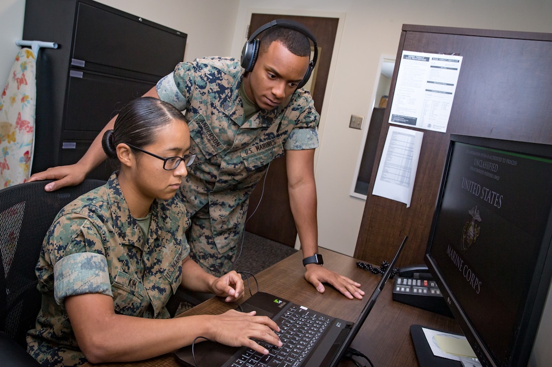 U.S. Marine Corps Sgt. Paul Anderson, right, court reporter non-commissioned officer in charge, and Lance Cpl. Christina Kim, a court reporter, both assigned to Headquarters and Headquarters Squadron, review audio files from a court case at the Legal Services building, Marine Corps Air Station Cherry Point, North Carolina, Aug. 8, 2019. Anderson and Kim are currently the only court reporters assigned to the Legal Service Support Team at Marine Corps Air Station Cherry Point (MCAS), North Carolina. (U.S. Marine Corps photo by Cpl. Micha Pierce)