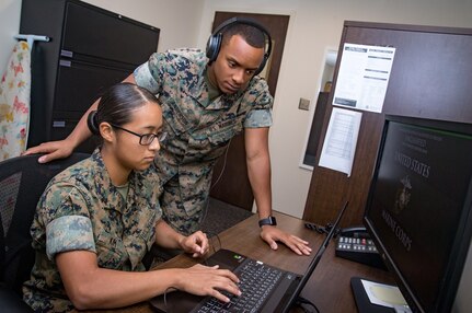 U.S. Marine Corps Sgt. Paul Anderson, right, court reporter non-commissioned officer in charge, and Lance Cpl. Christina Kim, a court reporter, both assigned to Headquarters and Headquarters Squadron, review audio files from a court case at the Legal Services building, Marine Corps Air Station Cherry Point, North Carolina, Aug. 8, 2019. Anderson and Kim are currently the only court reporters assigned to the Legal Service Support Team at Marine Corps Air Station Cherry Point (MCAS), North Carolina. (U.S. Marine Corps photo by Cpl. Micha Pierce)