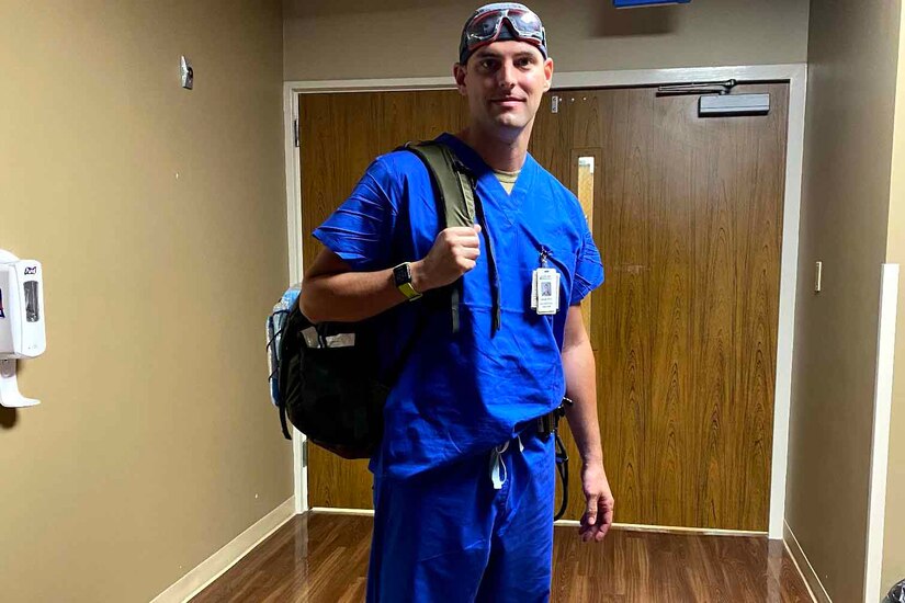 A nurse poses for a photo inside of a hospital.