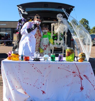 Bri Sovern, 50th Contracting Squadron key spouse, left, and Bobby, 11, stand with a skeleton during the trunk decorating contest Oct. 30, 2020, at Schriever Air Force Base, Colorado. Their mad scientist-themed trunk won the contest and they earned $500 for their creation. (U.S. Space Force photo by Marcus Hill)
