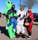 Eric McCullough, left, 50th Force Support Squadron community cohesion coordinator, Joe Montoya, center, 50th FSS visual assistant, and Jennifer Anthony, 50th FSS commercial sponsorship coordinator, get in the spirit of Halloween by wearing costumes to the 50th FSS trunk decorating contest at Schriever Air Force Base, Colorado on Oct. 30, 2020. The event provided pre-packaged candy, hot cocoa and free caramel apples to attendees. (U.S. Space Force photo by Marcus Hill)