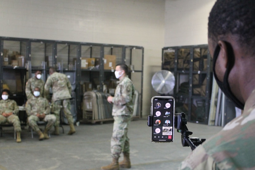 A U.S. Army Reserve Soldier monitors a cell phone during a live broadcast of primary marksmanship instruction for a battle assembly in Belle Chasse, Louisiana October 25, 2020.