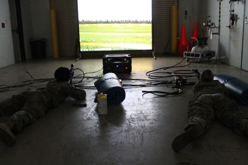Two Soldiers take aim at targets on the Engagement Skills Trainer II during a 377th Theater Sustainment Command battle assembly in Belle Chasse, Louisiana October 25, 2020.