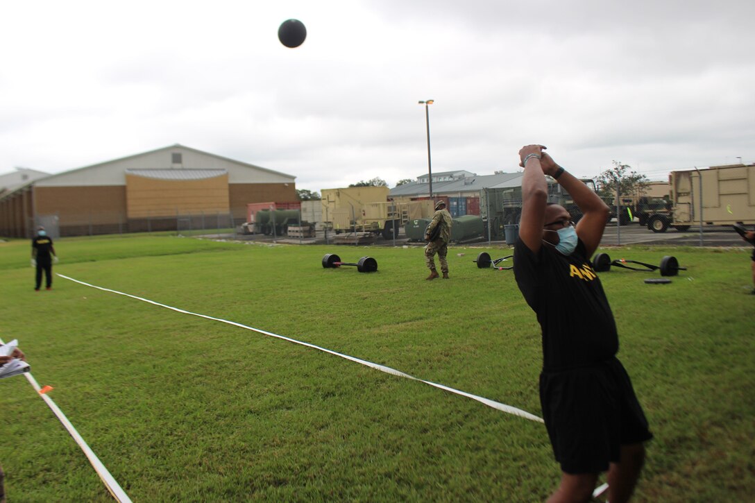 Lt. Col. Samuel Bates tosses a 10-pound medicine ball backwards overhead as part of the Standing Power Throw event during the Army Combat Fitness Test in Belle Chasse, Louisiana October 25, 2020.