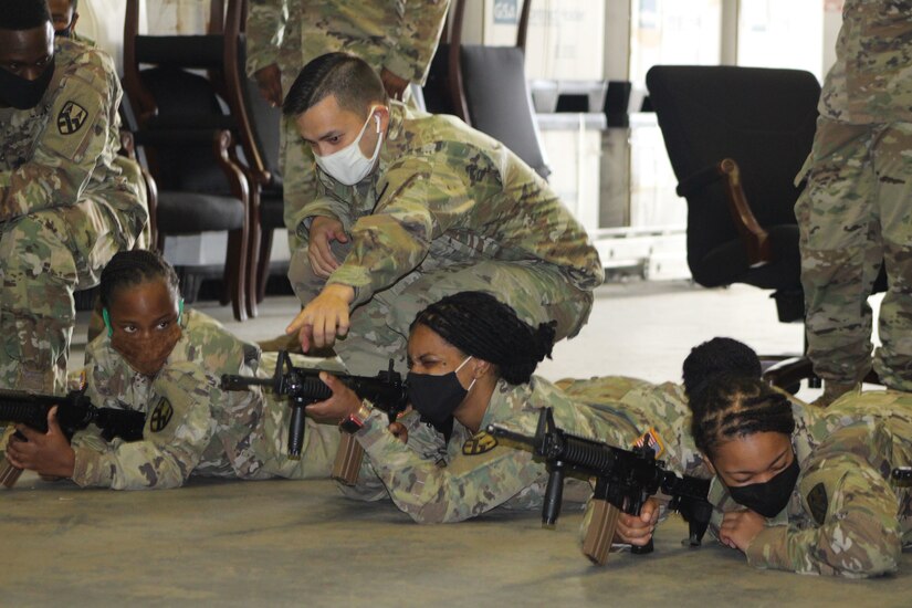 Staff Sgt. James Andrews assists a Soldier during  primary marksmanship instruction at a battle assembly in Belle Chasse, Louisiana October 25, 2020.
