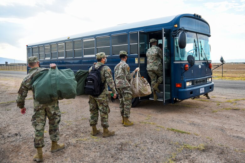 A photo of Airmen getting on a bus.