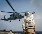 Chief Boatswain’s Mate Juan Vigil, from Las Vegas, sends off an MH-60R Sea Hawk helicopter from the Royal Australian Navy Anzac-class frigate HMAS Ballarat (FFH 155) as it takes off from the flight deck aboard the Arleigh Burke-class guided-missile destroyer USS John S. McCain (DDG 56) during flight operations