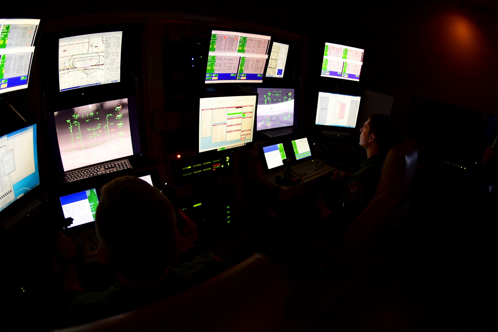 A pilot and sensor operator operate an MQ-9 simulator.