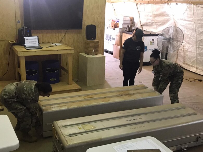 U.S. Airmen from the 768th Expeditionary Air Base Squadron Mortuary Affairs team examine transfer cases during a short-notice exercise at Nigerian Air Base 101, Niamey, Niger, Oct. 9, 2020.