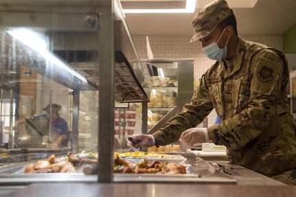 Airman Mr Gary Mcelrath, 628th Force Support Squadron food services apprentice, prepares meals on a food line at the Robert D. Gaylor Dining Facility at Joint Base Charleston, S.C., Nov. 2, 2020. Airmen and civilians who work at the dining facility work as part of a seven to 12 member team and serve meals to approximately 300 personnel during lunch hours. 628th FSS members ensure service members and civilians are fed at Joint Base Charleston, but feeding the force is just one mission that the FSS team is responsible for. The four core areas of services are food service, lodging, readiness, and fitness and sports.