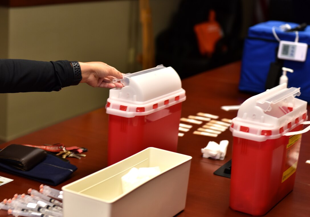 A 17th Medical Group member disposes of a used flu shot during the initial shot dispersal at the Norma Brown Building on Goodfellow Air Force Base, Texas, Nov. 2, 2020. Active duty members received their vaccines during the allotted time. (U.S. Air Force photo by Staff Sgt. Seraiah Wolf)
