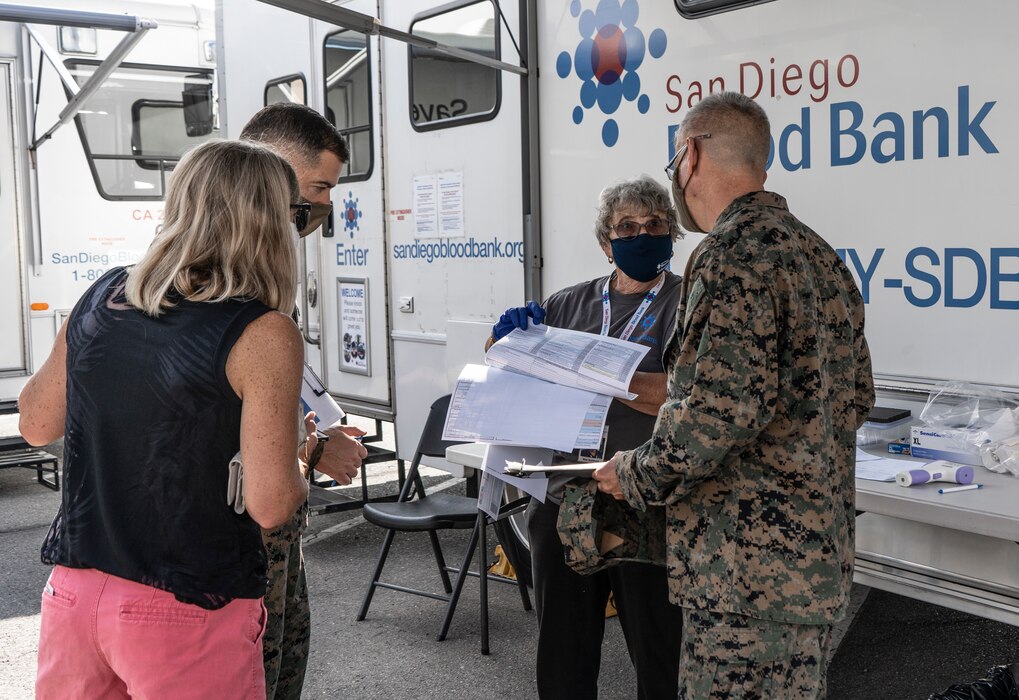 May Goldman, middle, a volunteer with the San Diego Blood Bank, explains the blood donation paperwork to U.S. Marine Corps Col. Christian Ellinger, Inspector General with Western Recruiting Region and Col. Rob Hancock, Assistant Chief of Staff, WRR, during a blood drive in memory of Lyanna Fernandez at Marine Corps Recruit Depot San Diego, Oct. 7, 2020. Fernandez was diagnosed with Leukemia July 17, 2019 and passed away two months before her second birthday. The blood drive was organized by the 12th Marine Corps District on behalf of Lyanna's father, Staff Sgt. Juan Fernandez. A single blood donation can save up to three lives. (U.S. Marine Corps photo by Cpl. Tessa D. Watts)