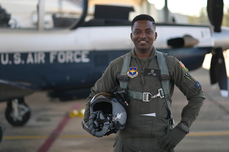 U.S. Air Force 2nd Lt. Clifford Mua, 41st Flying Training Squadron student pilot, stands in front of a T-6 Texan II before flight Nov. 4, 2020, on Columbus Air Force Base Miss. Mua completed his dollar ride, the first flight a student pilot takes during Specialized Undergraduate Pilot Training, and in keeping with tradition, presented his instructor pilot a decorated dollar after the flight was complete. (U.S. Air Force photo by Senior Airman Jake Jacobsen)