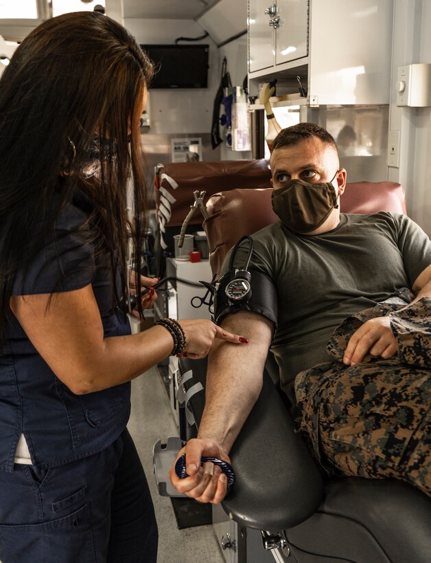 Veronica Badilla, a phlebotomist with the San Diego Blood Bank, locates a vein of U.S. Marine Corps Maj. Kyle Mcatee, a logistics officer with Headquarters and Service Battalion, Western Recruiting Region, during a blood drive in memory of Lyanna Fernandez at Marine Corps Recruit Depot San Diego, Oct. 7, 2020. Fernandez was diagnosed with Leukemia July 17, 2019 and passed away two months before her second birthday. The blood drive was organized by the 12th Marine Corps District and the San Diego Blood Bank on behalf of Lyanna's father, Staff Sgt. Juan Fernandez. A single blood donation can save up to three lives. (U.S. Marine Corps photo by Cpl. Tessa D. Watts)