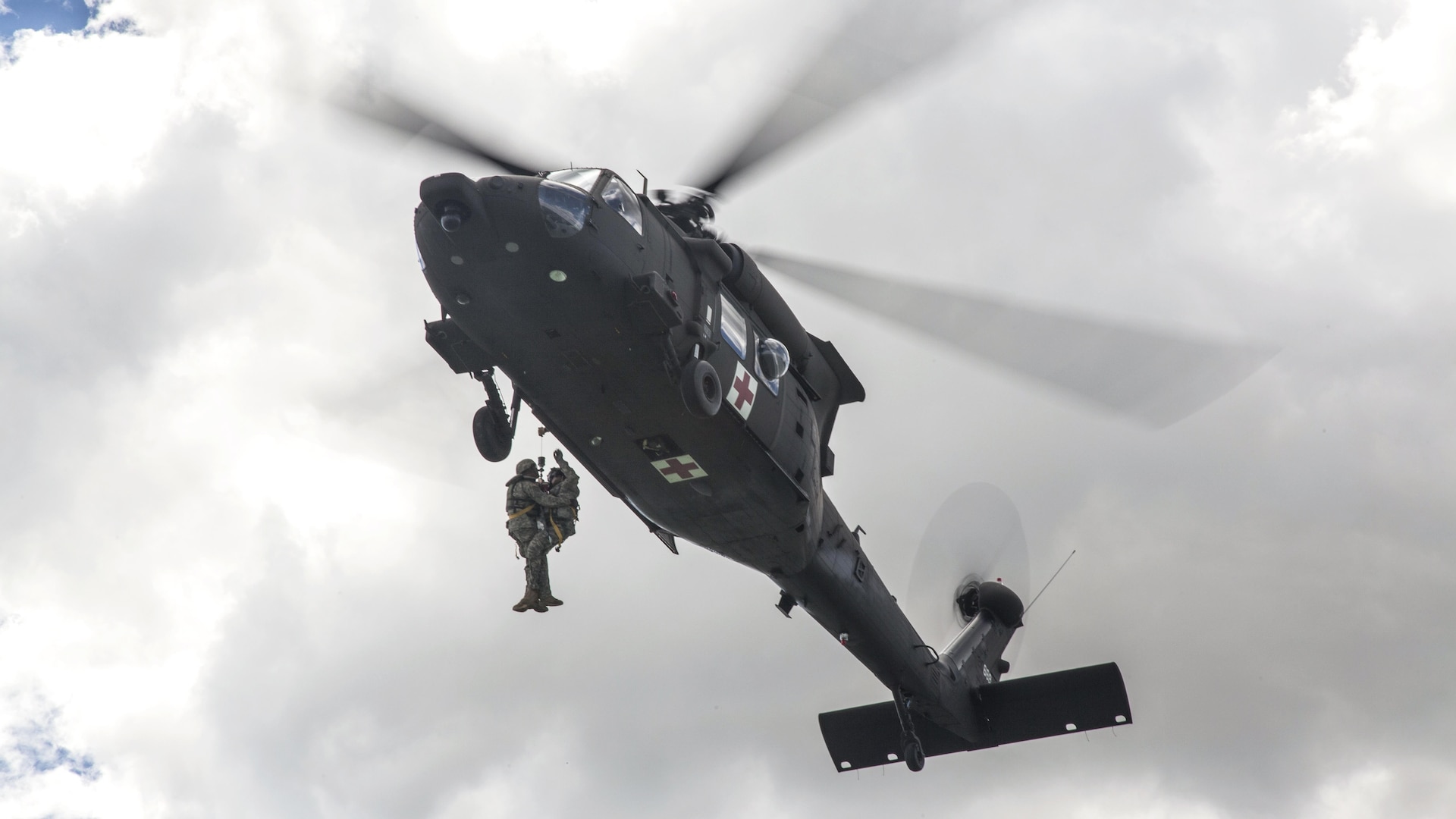 Soldiers hoist a simulated wounded soldier into an HH60-M Medevac Blackhawk during the Golden Coyote training exercise in Belle Fourche Reservoir, South Dakota, June 19, 2017.