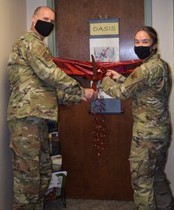 Col. Steven Anderson, 688th Cyberspace Wing commander, and Capt. Amy O’Connell, 688th Cyberspace Wing chaplain, cut the ribbon during a ceremony for the opening of The Oasis resilience room at Joint Base San Antonio-Lackland Oct.13. The resiliency room is stocked with books, a massage chair, a television, games and offers free resources for 688th Cyberspace Wing Airmen.