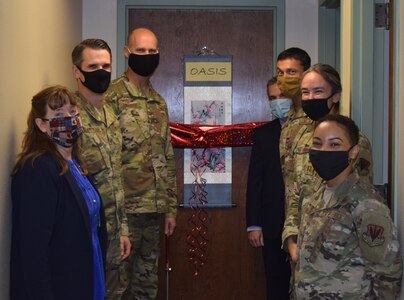 (From left) Linda Roque; Col. Jeffrey Blankenship; Col. Steven Anderson, 688th Cyberspace Wing commander; Jay Aragon; Chief Master Sgt. Israel Jaeger; Capt. (Chaplain) Amy O’Connell; and Staff Sgt. Jasmine Jones, attend a small ribbon-cutting ceremony celebrating the opening of The Oasis resiliency room at Joint Base San Antonio-Lackland Oct.13. The resiliency room is stocked with books, a massage chair, a television, games, and offers free resources for 688th Cyberspace Wing Airmen.