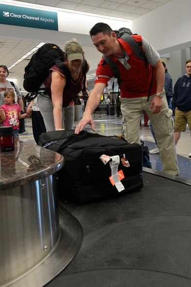 2nd Lt. Kelly Davis, 1st Special Operations Contracting Squadron, Hulbert Field, Florida, officer in charge infrastructure, helps Master Sgt. Roger Hartzell, 1st Special Operations Contracting Squadron, Hulbert Field, Florida, infrastructure flight superintendent, remove his luggage from the airport luggage carousel, March 14, 2017, at El Paso International airport, Texas.