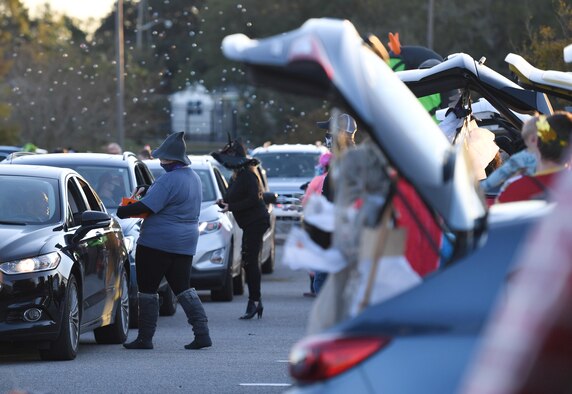Keesler personnel pass out candy to Keesler families during the Ghouls in the Park drive-thru event at the Bay Breeze Event Center parking lot at Keesler Air Force Base, Mississippi, Oct. 30, 2020. The 81st Force Support Squadron hosted the "trunk or treat" event for children of all ages. (U.S. Air Force photo by Kemberly Groue)